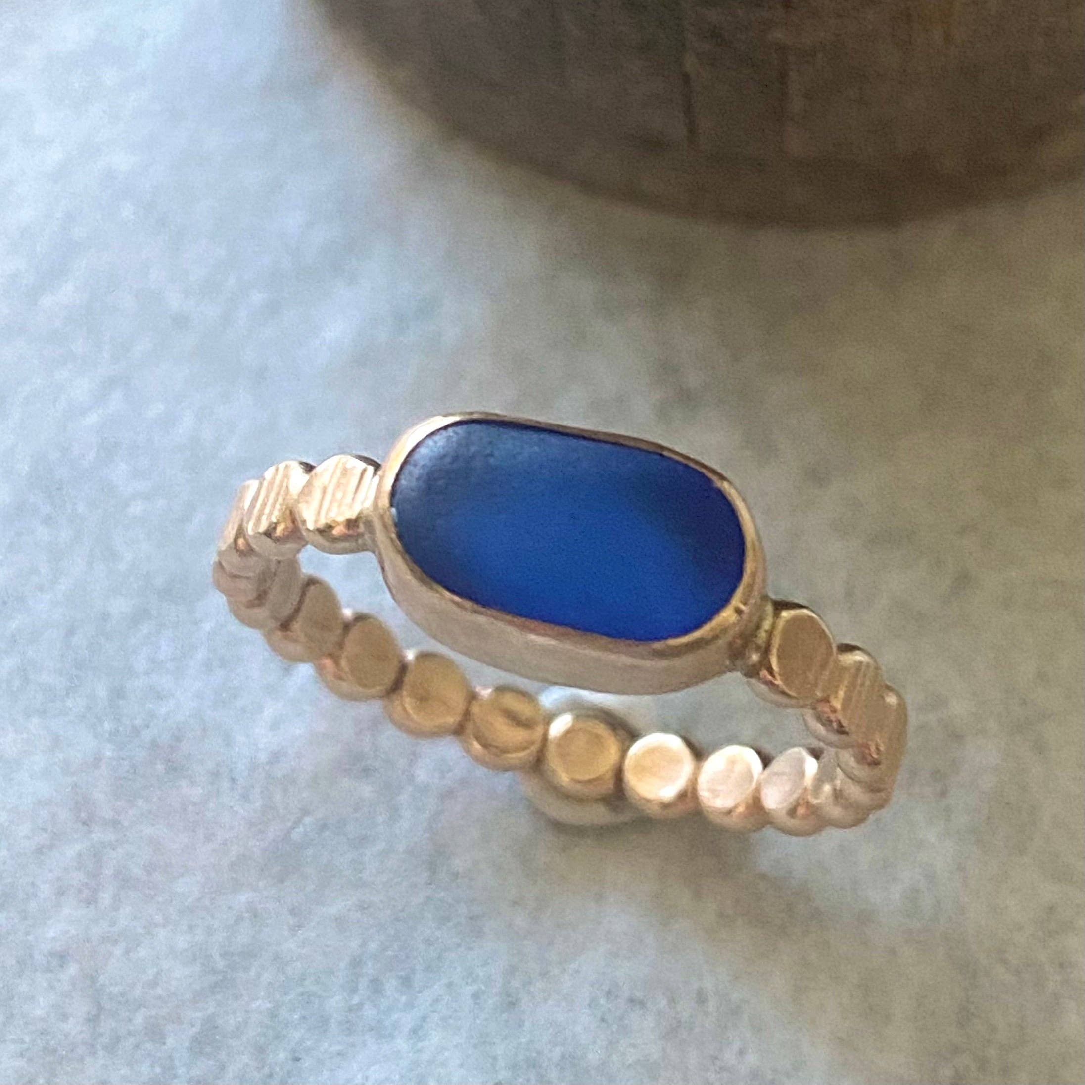 The Repetition Band by Kate Samson Design, featuring a distinctive sea glass ring in a rich blue color, set in a 14k gold fill bezel with a handmade beaded band.