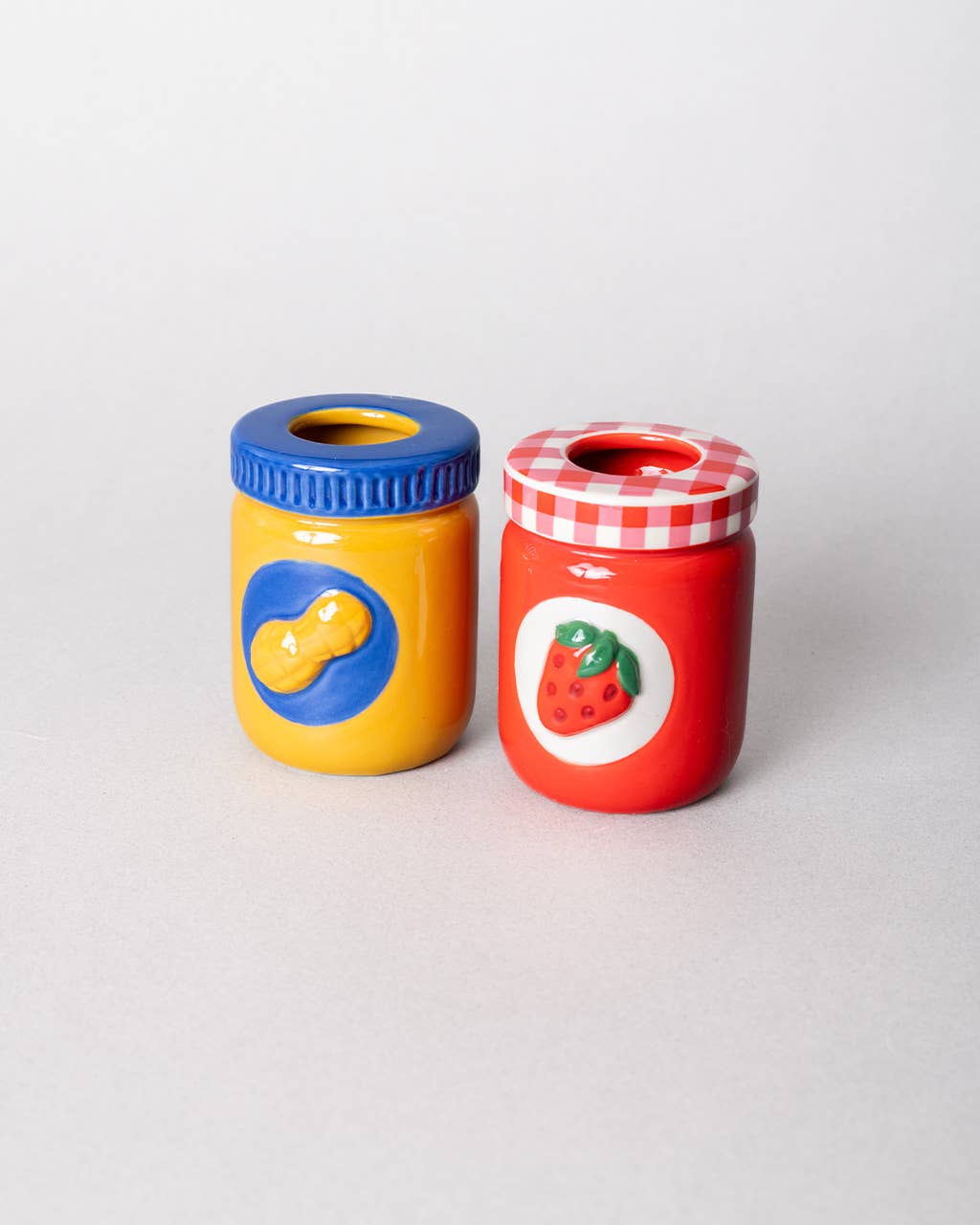 Two colorful jars with blue and red lids 