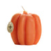 Orange pumpkin-shaped candle with a visible brand tag 