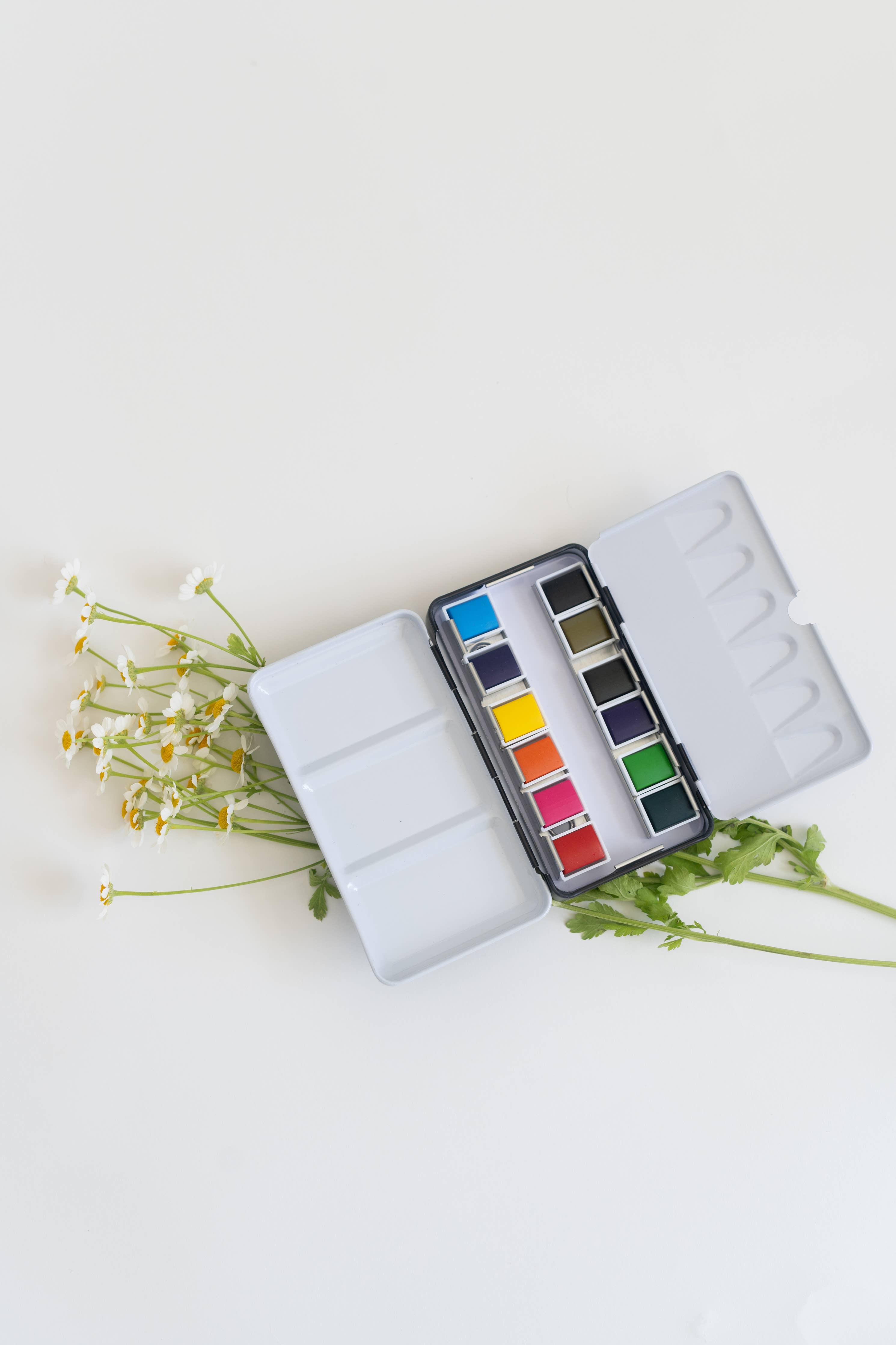 Versatile 12 Color Mini-Travel Watercolor Paint Palette featuring a refillable watercolor brush for easy painting.