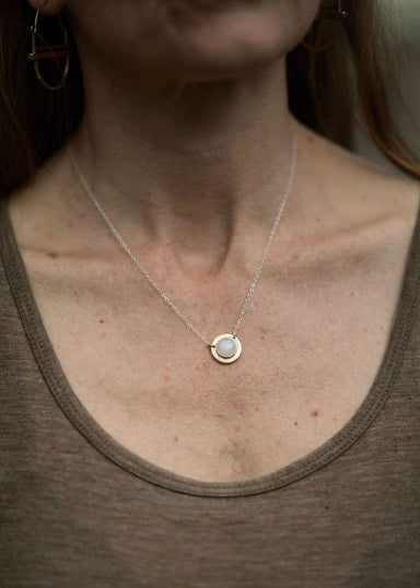  woman wearing rainbow moonstone with a silver chain. 