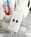 Woman wearing Eco Glass Bezel Drop Silver Earrings: Aqua, paired with a casual outfit, demonstrating versatility and style.