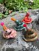 Colorful Itty Bitty Party Snake Sculptures by Bianca Rae, featuring various snakes with party hats and pom poms, showcasing assorted colors and playful designs, perfect for cake toppers or decorative accents.