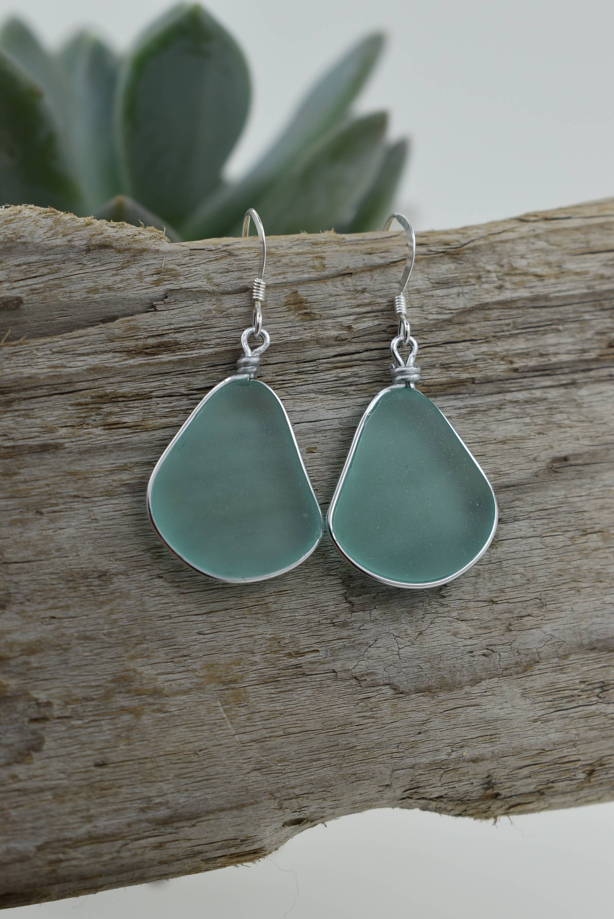 Model wearing Eco Glass Bezel Drop Silver Earrings in Aqua, demonstrating their lightweight comfort and stylish appeal.