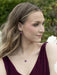 Close-up of Budding Heart Pendant showcasing its etched bloom and shimmering pearl, because who wouldn't want to wear nature’s most romantic love letter?