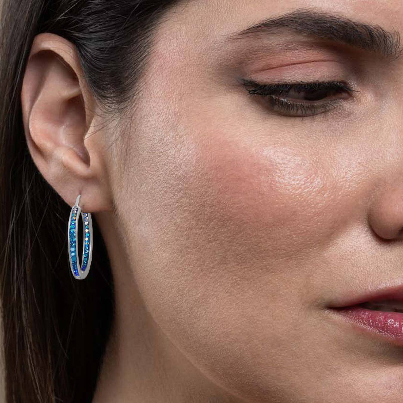 Stylish model wearing Mosaico Jewels extra large hoop earrings with crystals and silver, demonstrating versatility in fashion styles.