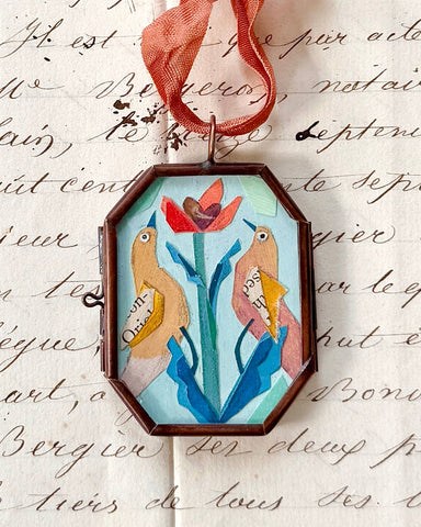 Vintage-style folk bird art locket ornament.