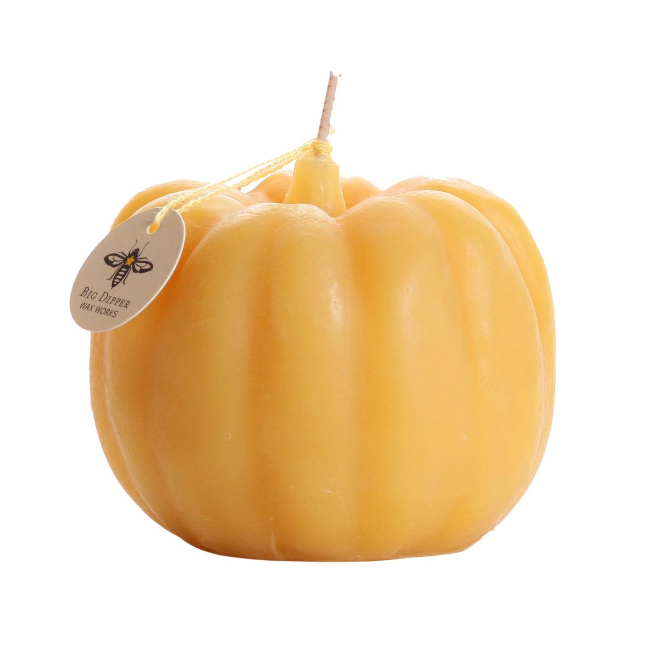Yellow pumpkin-shaped candle with a tag 