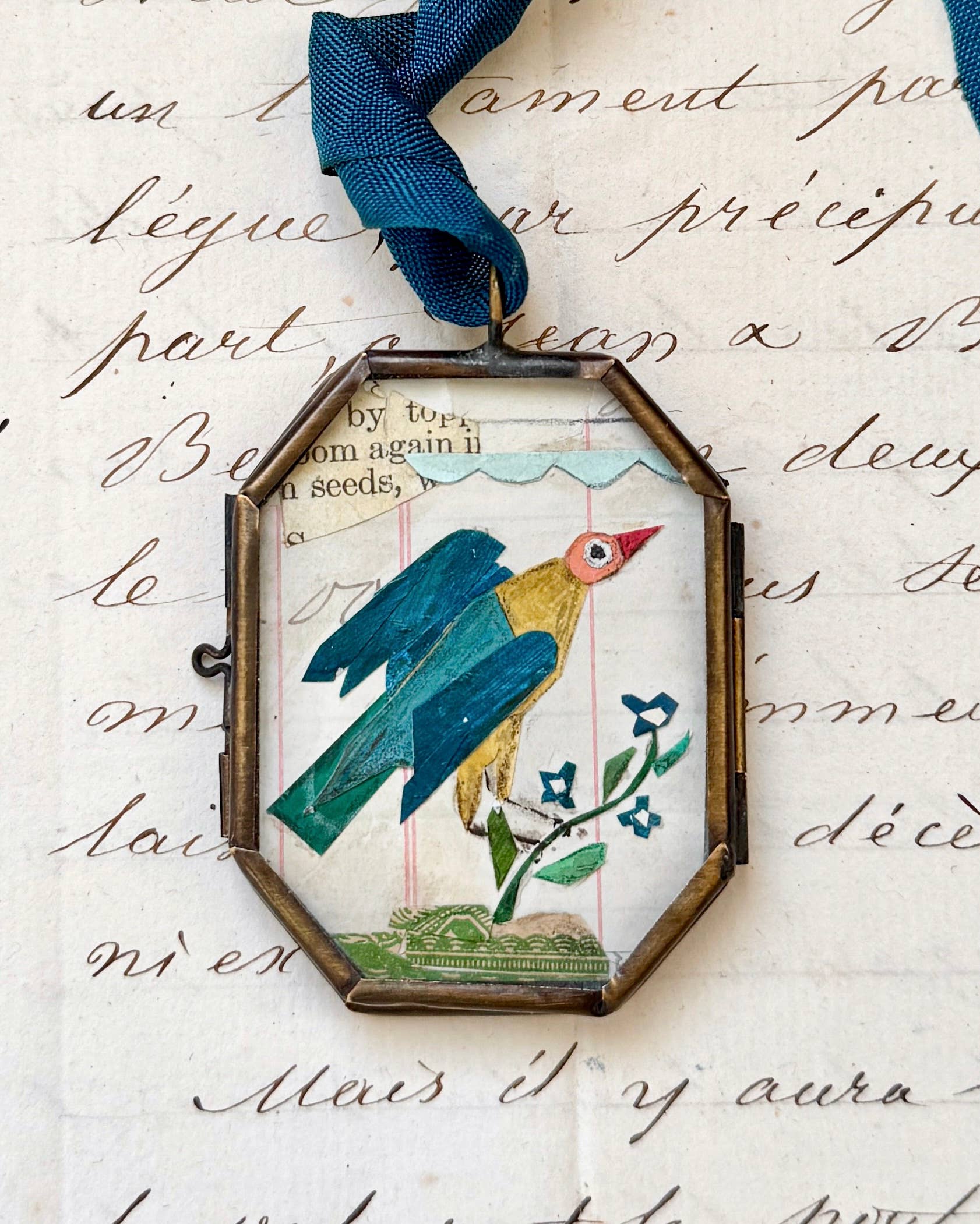 Vintage-style folk bird art locket ornament.