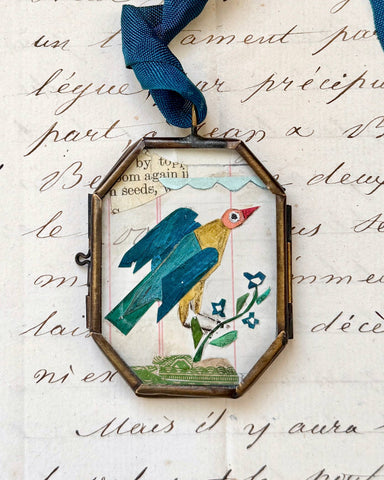 Vintage-style folk bird art locket ornament.