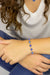 Person wearing a blue beaded bracelet 