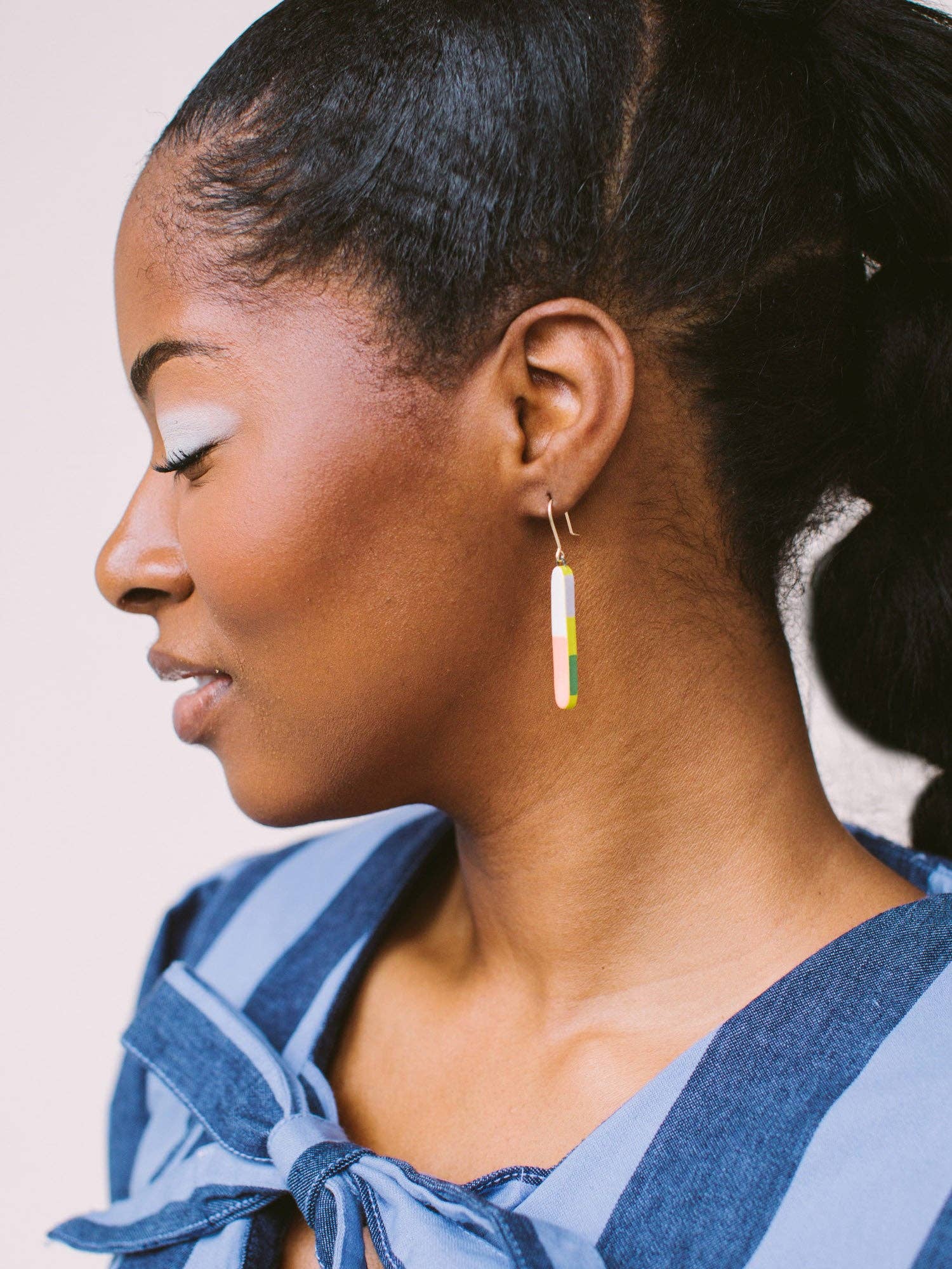 Close-up of a model wearing Skinny Dip Earrings, highlighting the earrings' vibrant colors and delicate design, created by Twenty Two West.