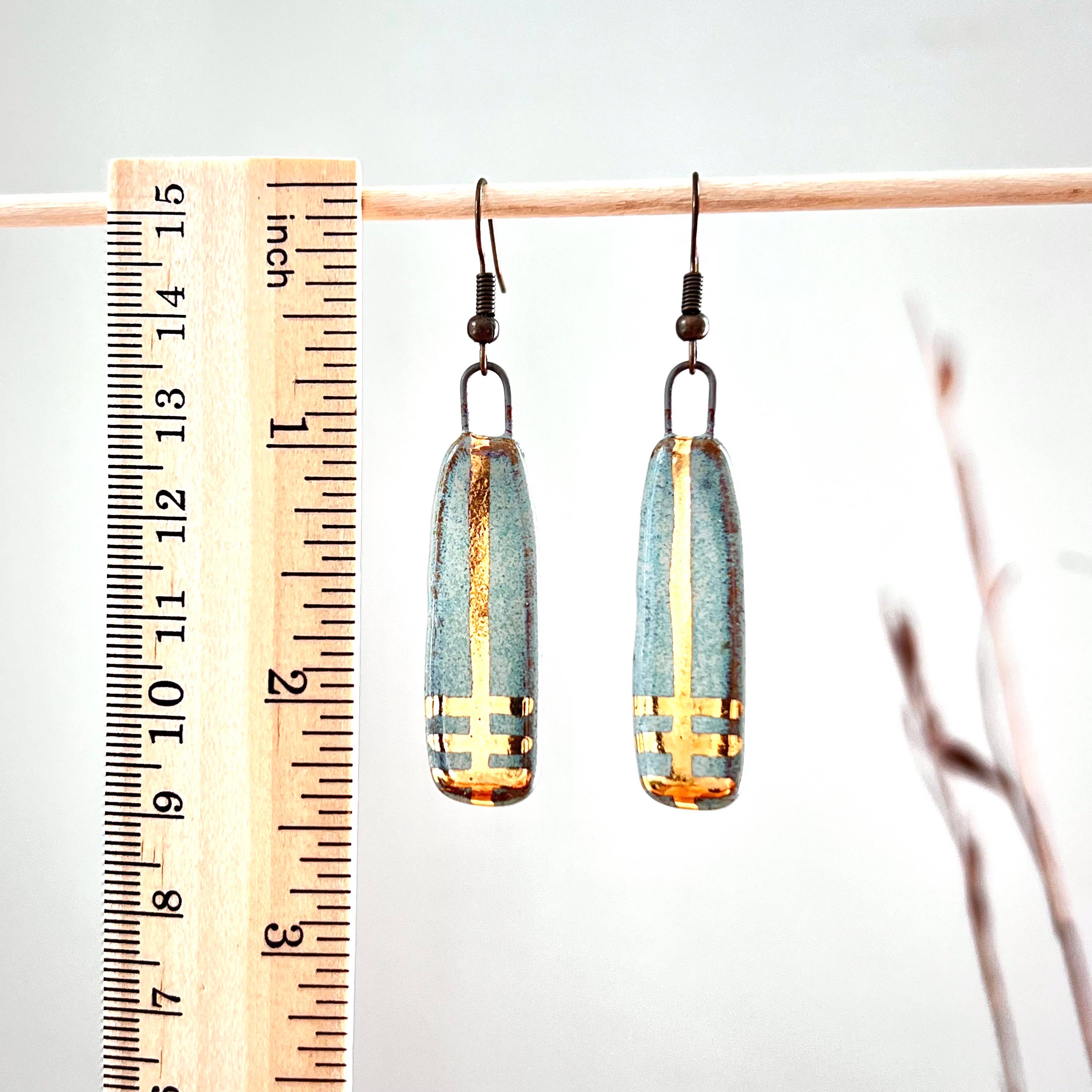 Turquoise Long Line Designed Earrings from The Artifact House next to a ruler for scale, showcasing their elegant design and craftsmanship.