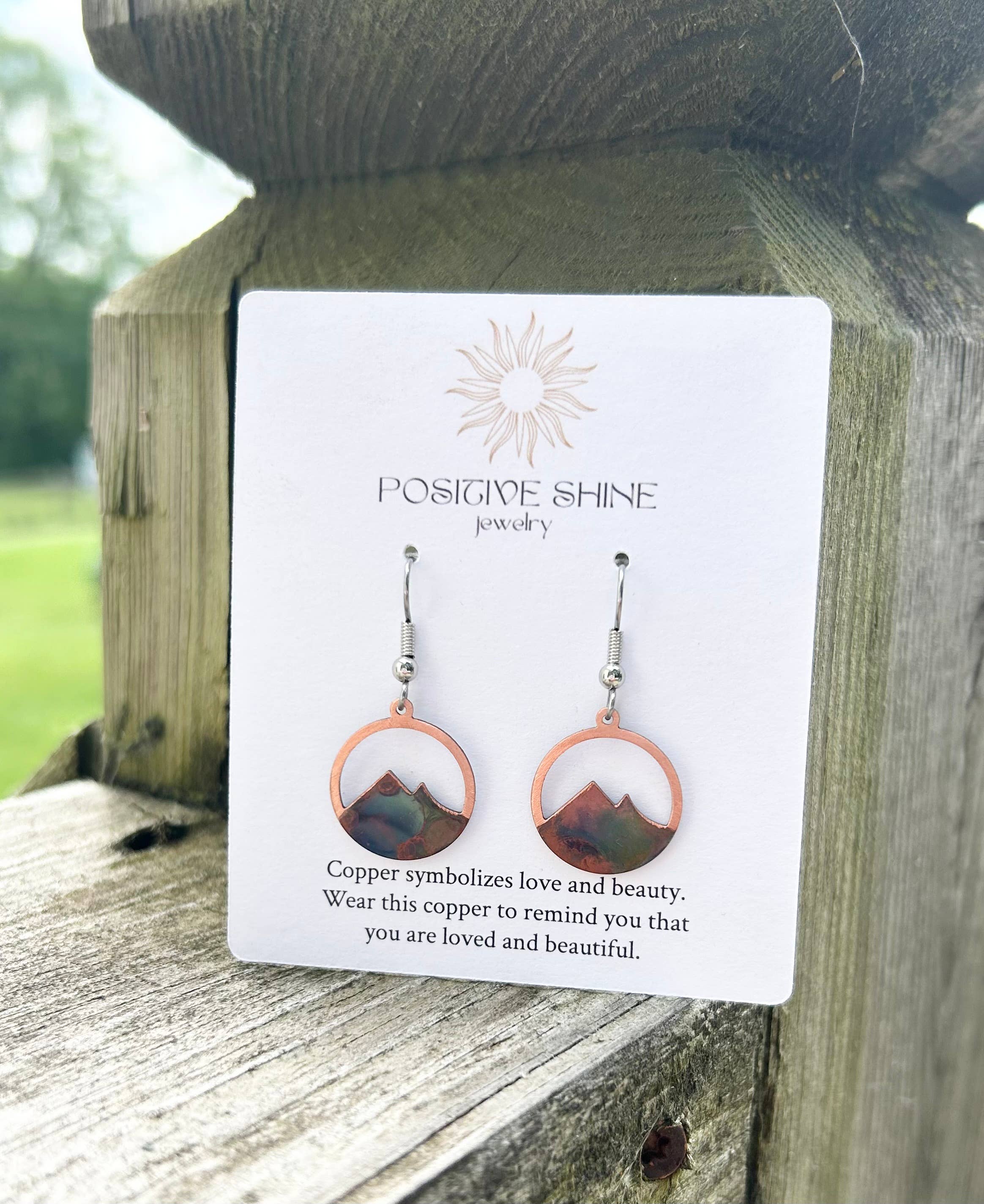 Close-up view of Circle Mountain Earrings showcasing bright colors and intricate copper detailing.