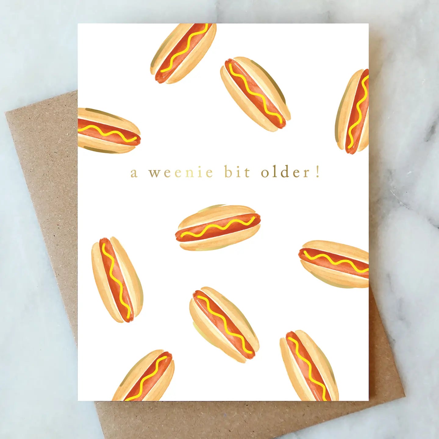 A whimsical birthday card saying 'a weenie bit older!' with colorful hot dog illustrations by Abigail Jayne Design from the Abigail Jayne Card Collection.