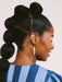 Side profile of a model with long hair, wearing Skinny Dip Earrings that complement the blue striped top, designed by Twenty Two West.