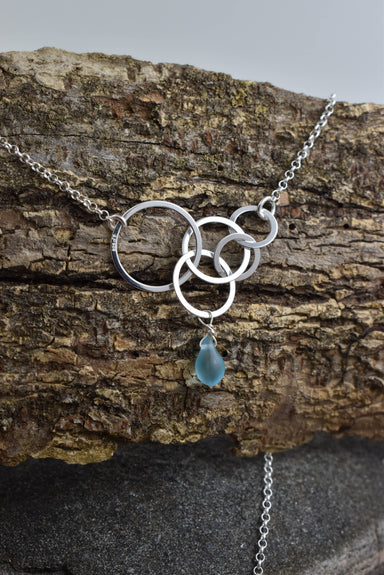 Aqua Eco Glass Sterling Silver Circle Necklace showcasing the intricate interlocking sterling silver circles and a stunning aqua Eco Glass teardrop pendant.