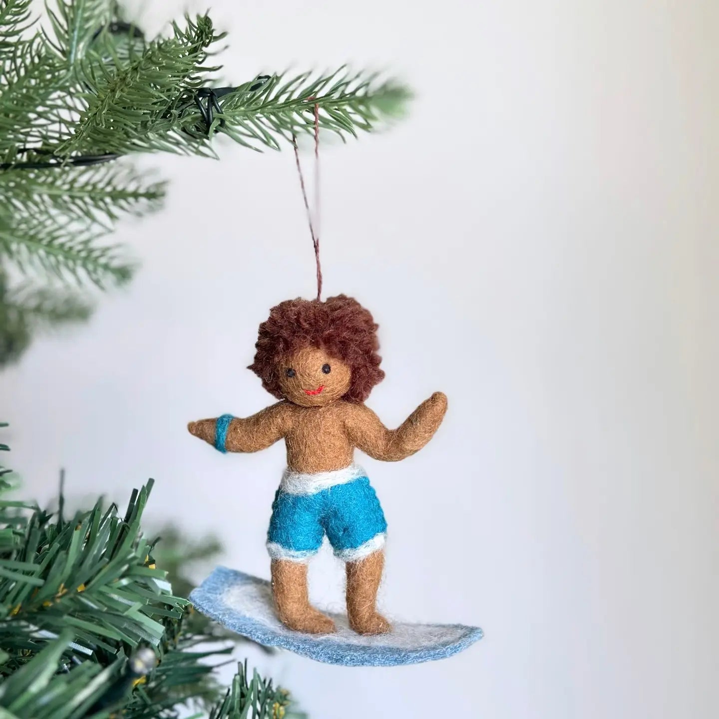 Felt Surfer Boy Ornament in white, celebrating summer vibes with a cheerful expression, perfect for holiday decor.