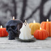 Halloween-themed candles including a skull, ghost, and pumpkins