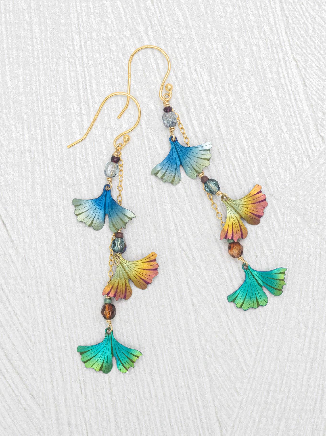 Ginkgo Chime Earrings by Holly Yashi featuring vibrant blue, green, and gold niobium leaves, perfect for adding a splash of color and whimsical movement to your outfit—because why should your ears miss out on the fun?