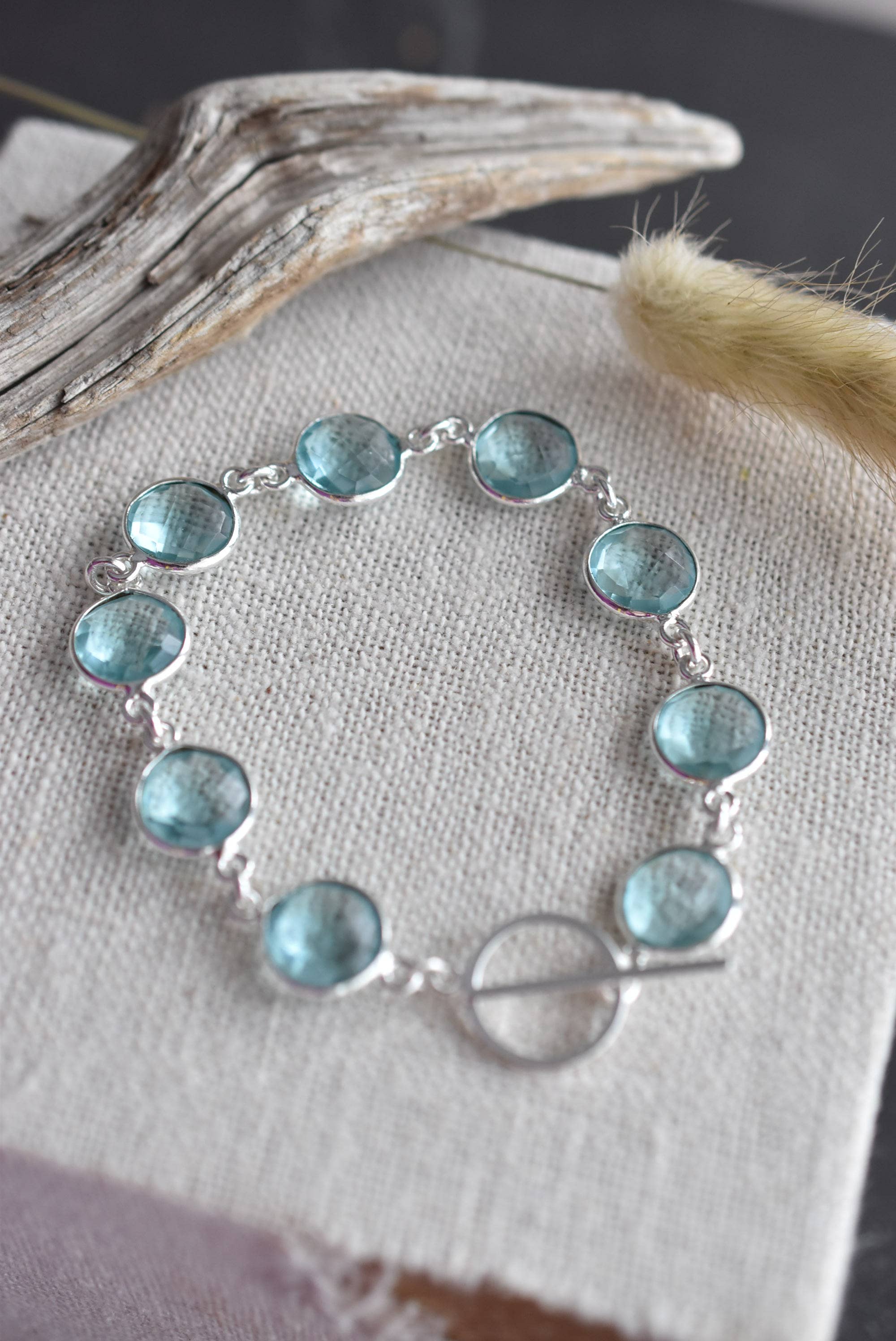 Artisan-crafted sterling silver sky blue topaz bracelet with bezel-set gemstones and secure toggle clasp, designed by Whitelotus Design.
