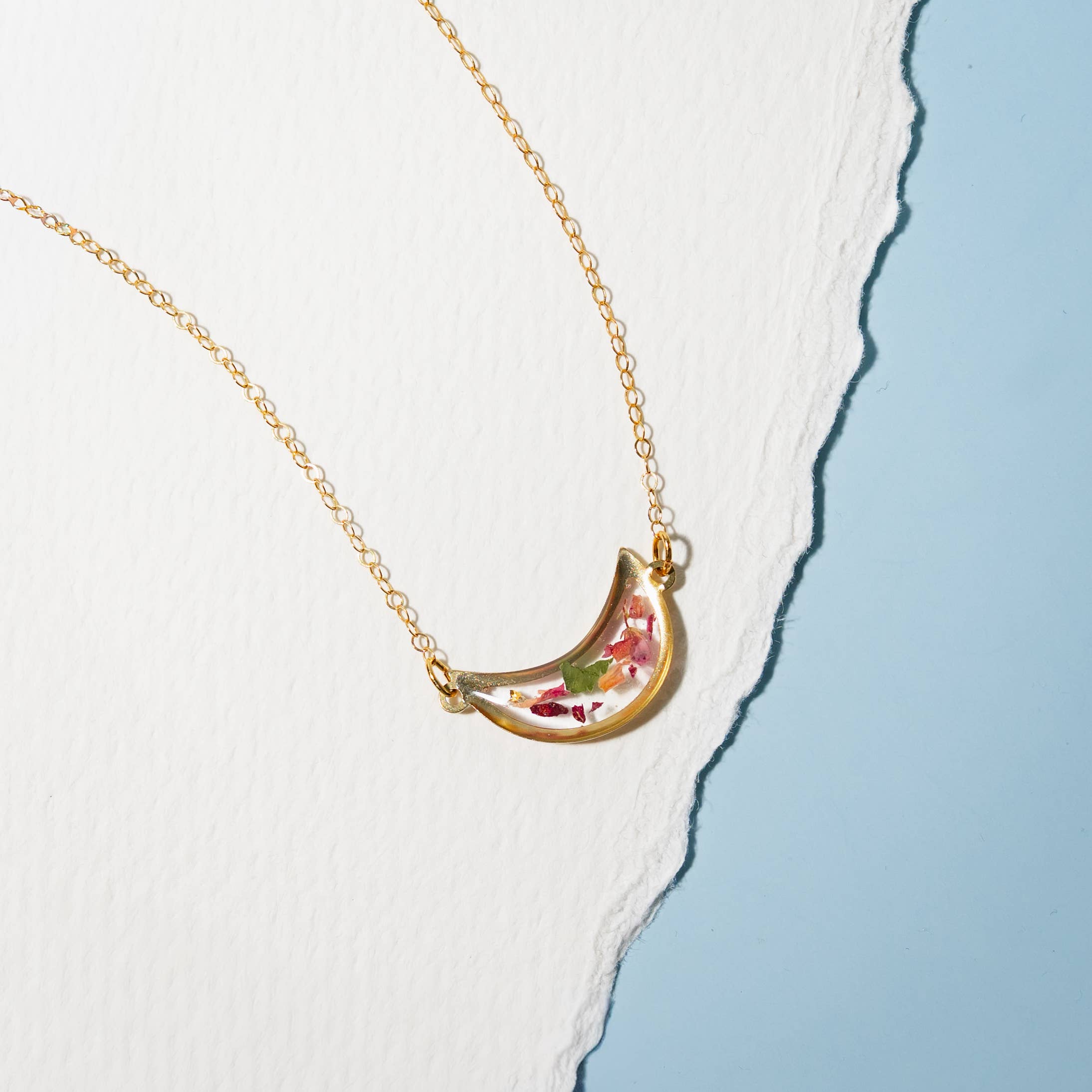 Close-up view of the Moon Petal Confetti Gold Filled Necklace highlighting the intricate details of the moon pendant and gold filled chain.