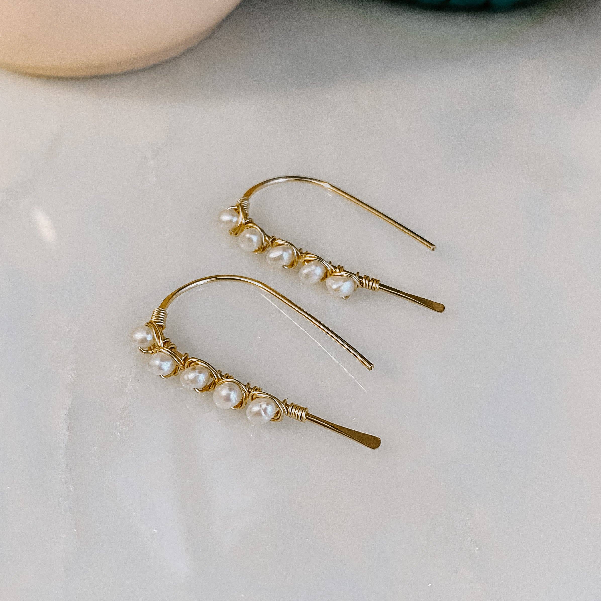 Mini Pearl U Shaped Threader Earrings being worn by a model, effortlessly winning the 'Best Supporting Accessory' award on the fashion runway.