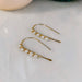 Mini Pearl U Shaped Threader Earrings being worn by a model, effortlessly winning the 'Best Supporting Accessory' award on the fashion runway.