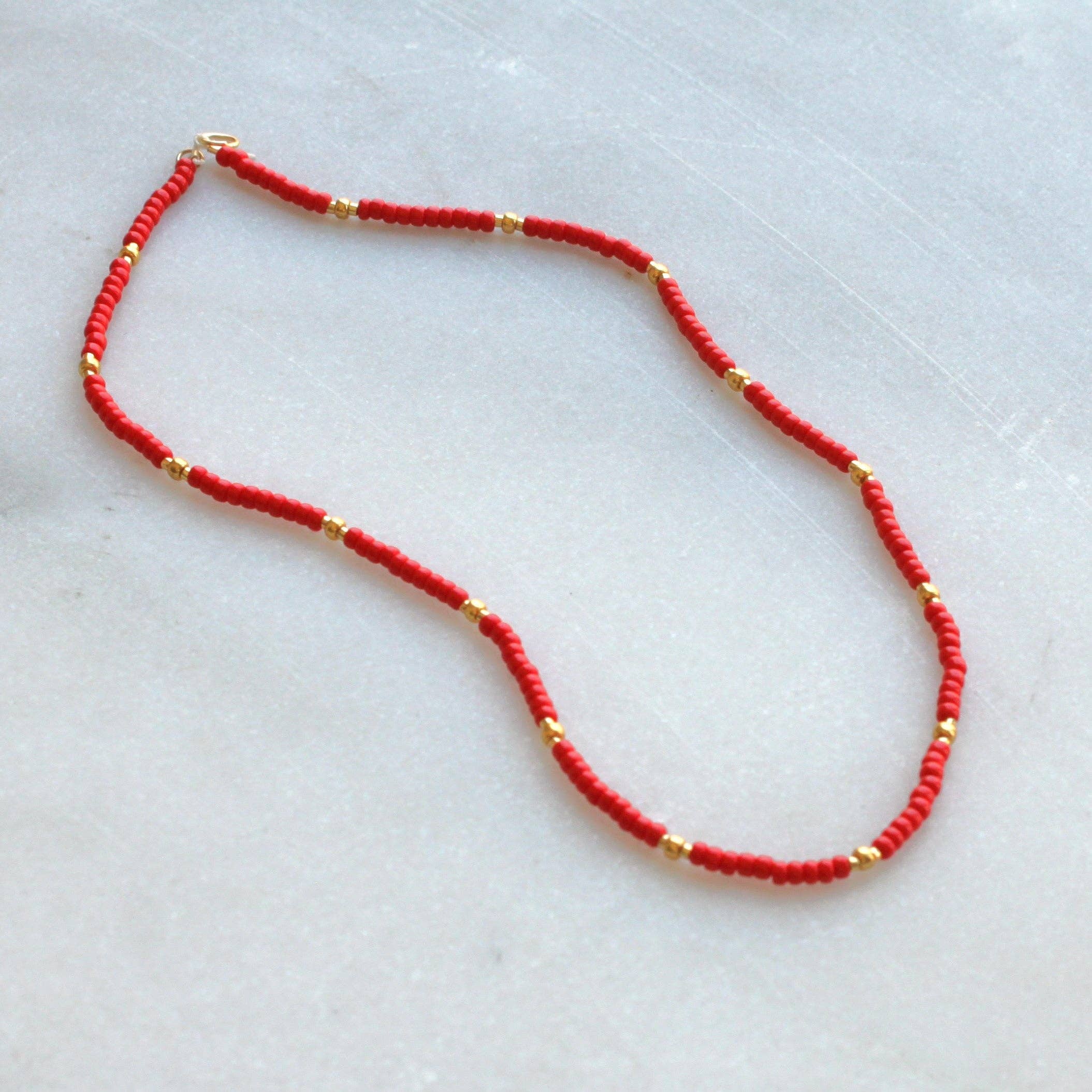 Close-up of the Lettie Seed Bead Necklace by The Silver Wren, highlighting the red seed beads interspersed with gold accents.