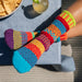 Colorful Cosmos Crew Socks by Solmate Socks featuring vibrant hues of orange, red, turquoise, lime green, and purple for a joyful and cozy look.