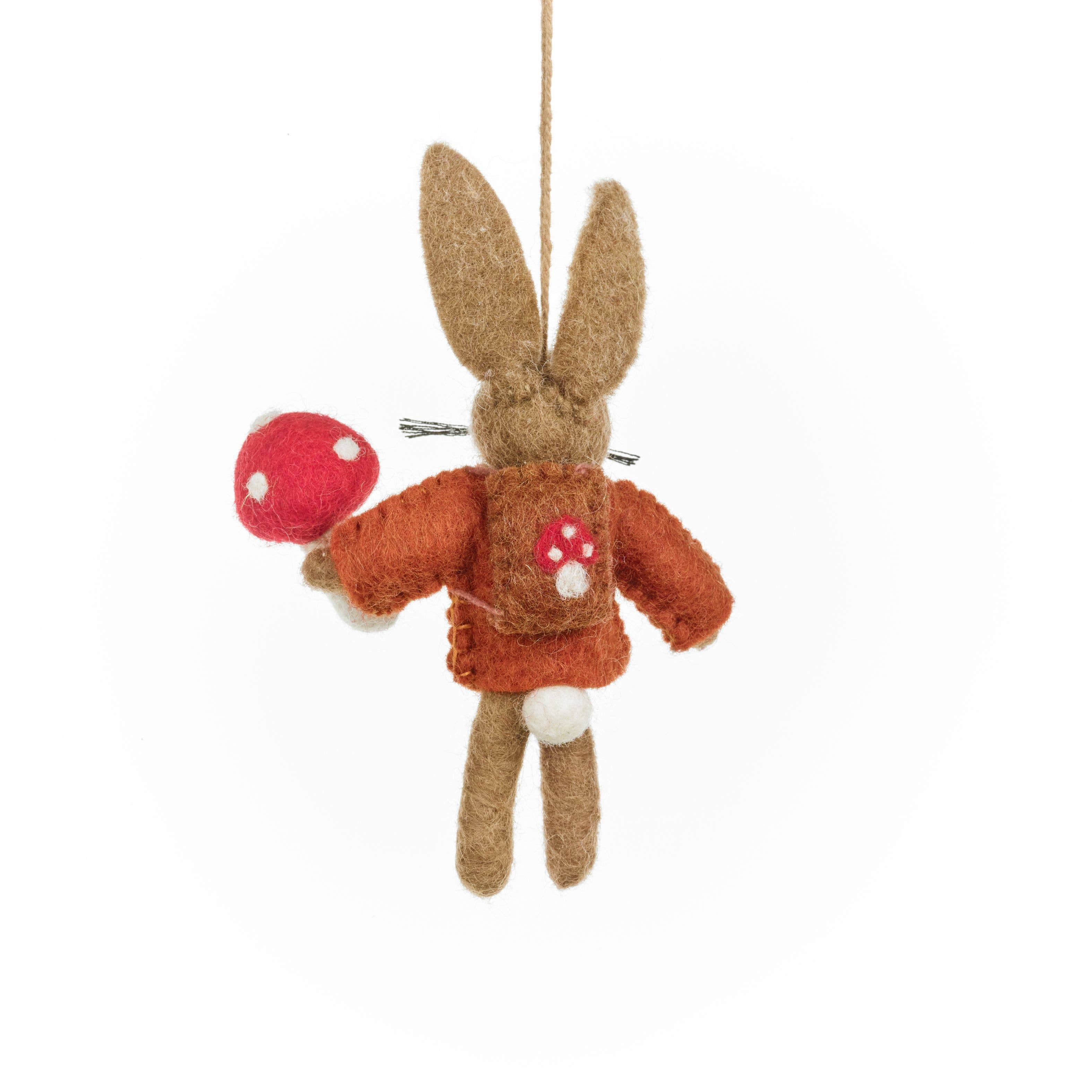 Felted rabbit ornament holding a red mushroom