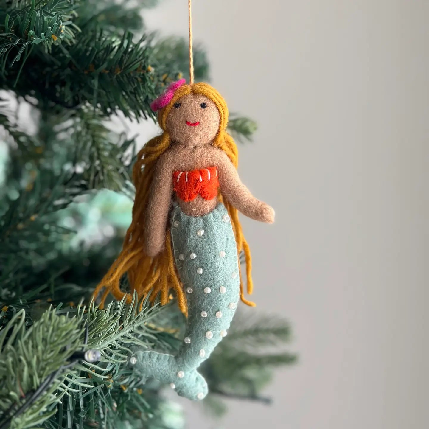 Cheerful Felt Mermaid Ornaments by Ganapati, showcasing vibrant colors, flowing black yarn hair, and seashell tops, perfect for adding coastal magic to your holiday decor.