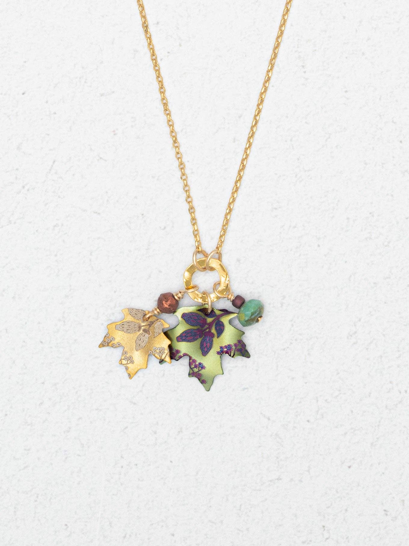 A whimsical Maple Charm Pendant Necklace by Holly Yashi, showcasing hand-painted maple leaves and gemstones, perfect for those who want to carry a piece of autumn fashion with a splash of sparkle!