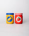 Two colorful ceramic jars, one yellow and blue lid with peanut and one red with a strawberry