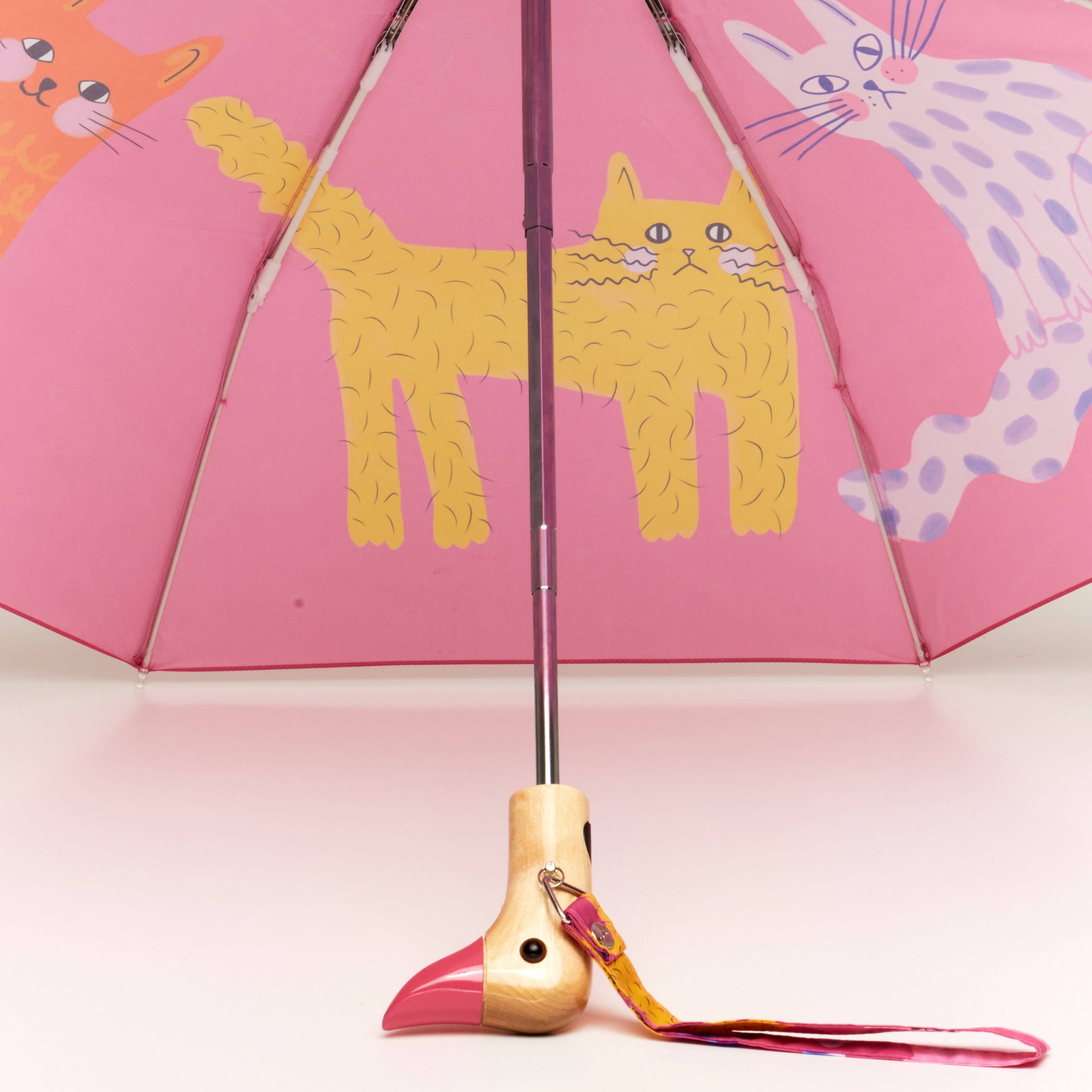 Close-up view of the charming duck-head handle on a pink Arty Cats Duck Umbrella by Original Duckhead USA, showcasing its whimsical design.
