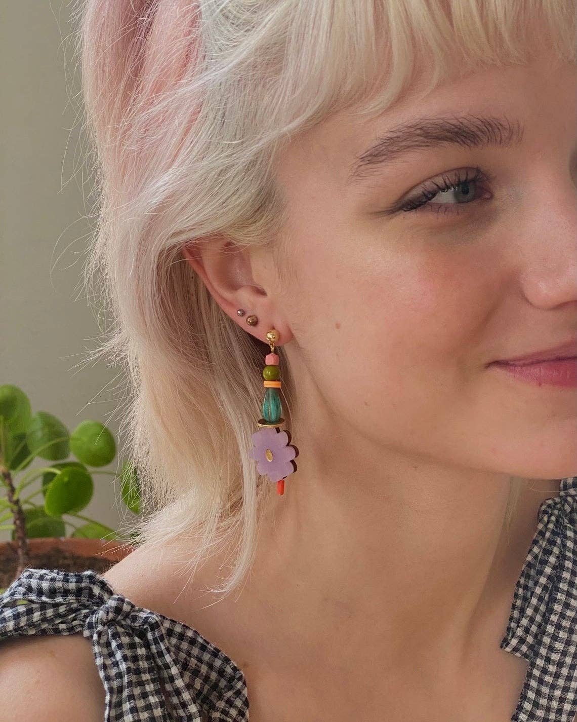woman wearing acrylic beaded and flower drop earrings
