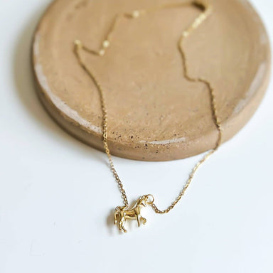 A close-up view of The Horse Girl Necklace, showcasing its shiny 14k gold-plated brass horse pendant, because every girl needs a stable of elegance around her neck!
