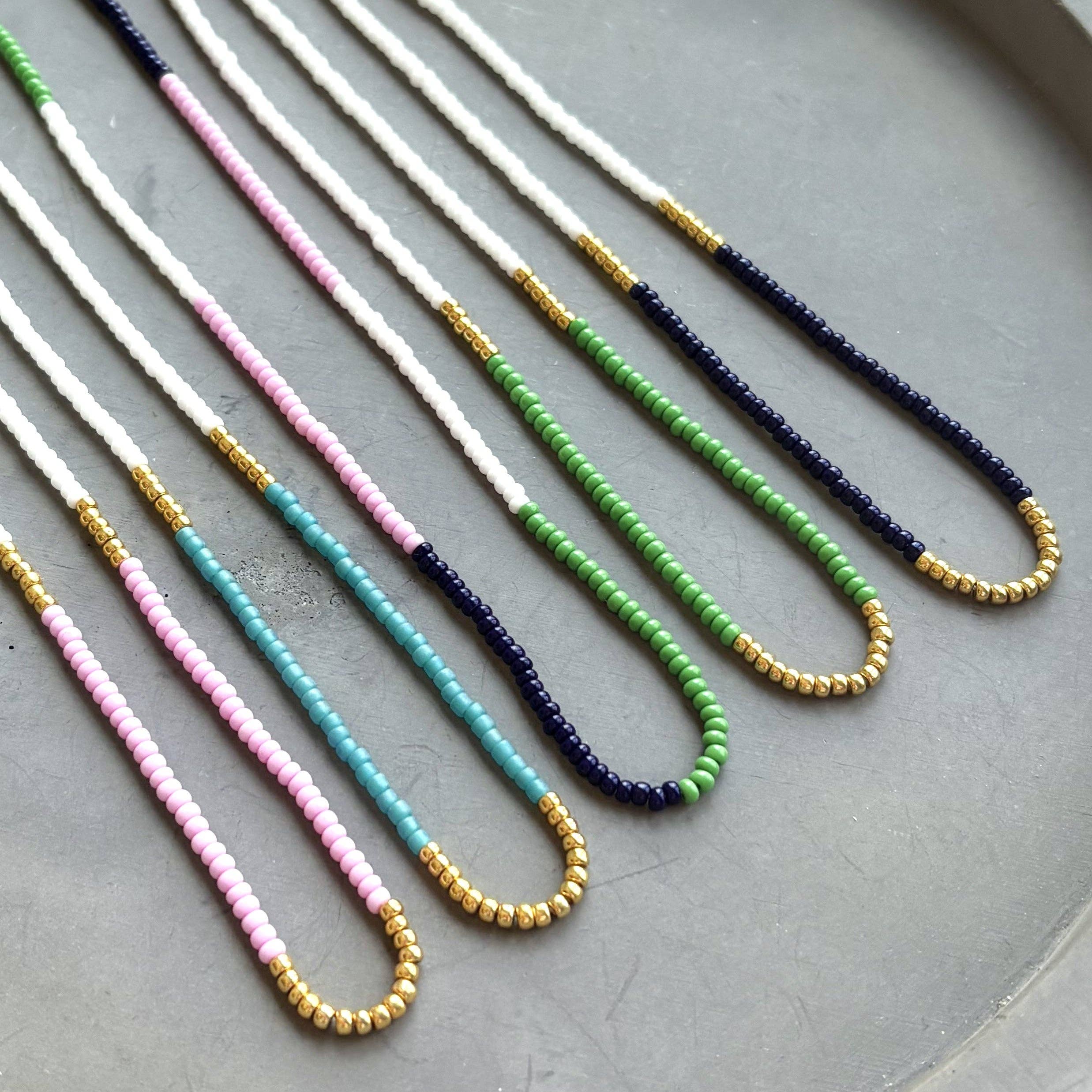 Lithe No. 2 Beaded Necklace by The Silver Wren, showcasing multicolor seed beads with vibrant green, turquoise, and deep navy tones on a textured background.