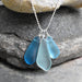 The Blue Eco Glass Trio Sterling Silver Necklace worn elegantly on a model, complementing a casual outfit with a touch of coastal charm.