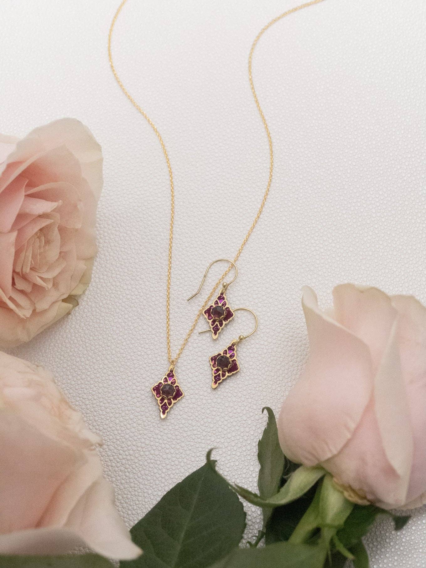 Esme Earrings elegantly displayed, showing off their 18K Gold-plated beauty and floral filigree design. A touch of charm just waiting to dress up your lobes!