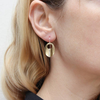 Close-up view of Small Wrapped Brass Oval Wire Earrings showcasing their elegant brass cutout and stylish wire wrapping.