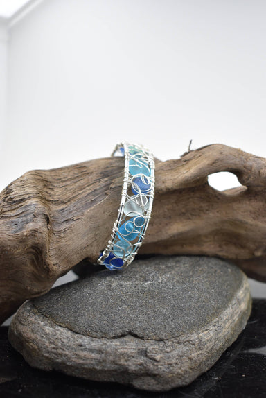 Close-up view of the modern wire woven eco glass cuff bracelet, highlighting the intricate silver-plated design and frosted glass pebbles for a unique artisan piece.