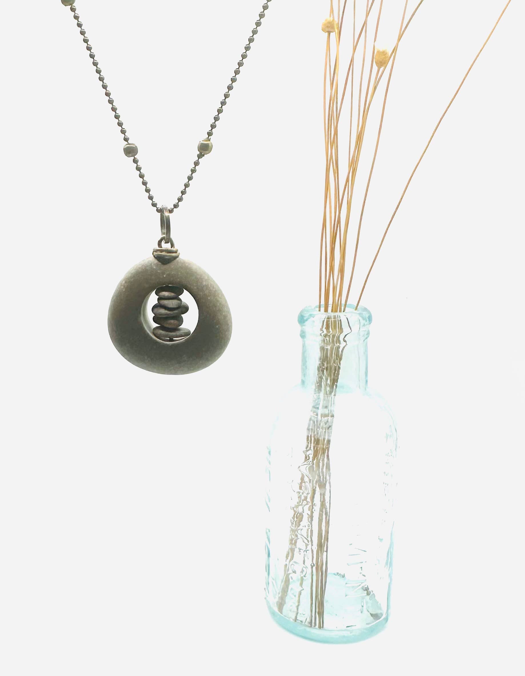 Brass Short Cored River Stone Stack by Suzanna Garrett Designs — this pendant turns a river stone into a tiny frame for an even tinier pebble stack