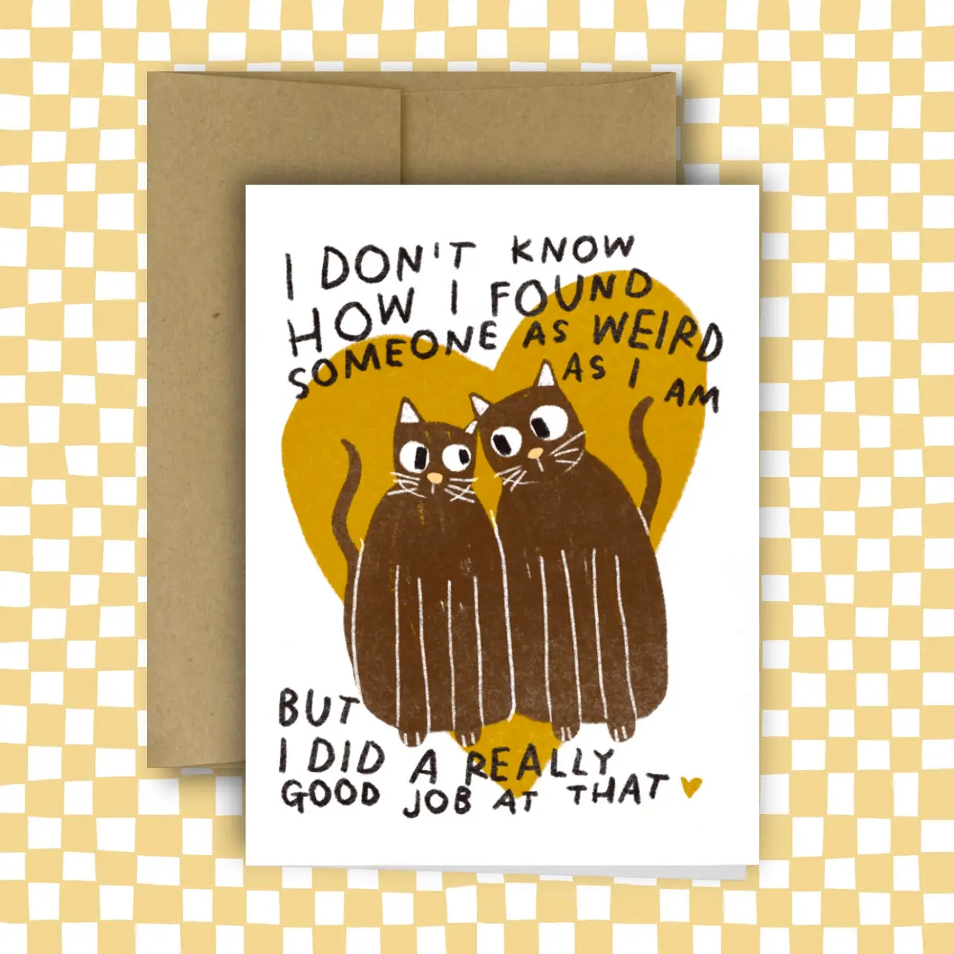 Greeting card with two cats and humorous text on a checkered background