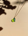 Mini Pear Necklace by Sunnie Creative featuring a unique handmade green acrylic pear pendant with a leaf, showcasing its delicate design.