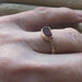 The Repetition Band | Sea Glass Ring by Kate Samson Design, featuring a unique piece of red sea glass set in a hand-crafted 14k gold bezel, showcased on a hand with a delicate decorative band.