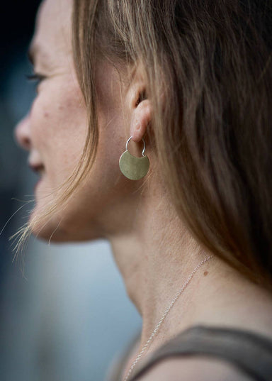 woman wearing Small disc circle hoop earrings