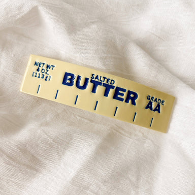 Playful image of the Butter Together Barrette by Meadow & Mae, showcasing its unique 4x6 inch size, ideal for keeping hair stylishly in check while also humorously nodding to the love for butter.