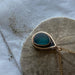 Stylish display of the Mermaid Tear Necklace showcasing its one-of-a-kind sea glass design and elegant gold accents.