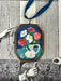 Vintage-style flowers in a vase art locket ornament.